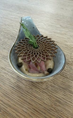 Amuse-Bouche auf einem Keramiklöffel mit Tuile.